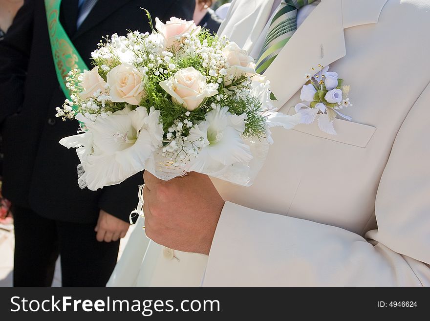 White rose bouquet in the hand of the groom. White rose bouquet in the hand of the groom