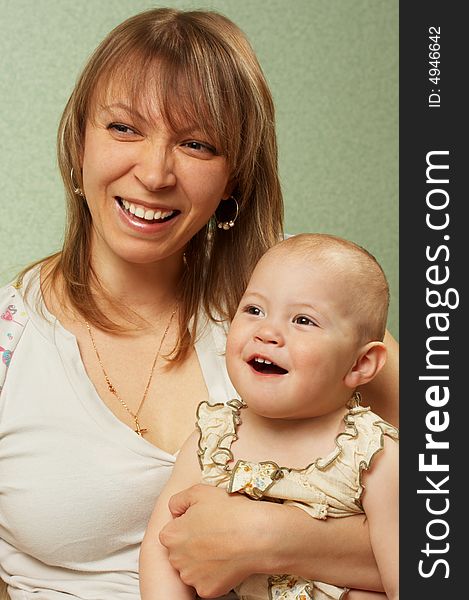Smiling mother with the child on a green background. Smiling mother with the child on a green background