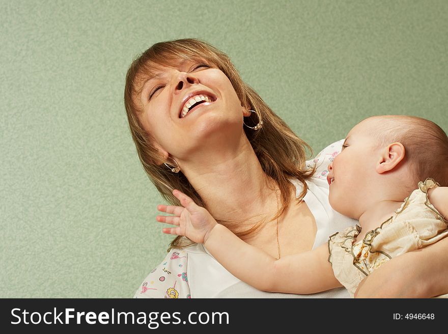 Smiling mother with the child on a green background. Smiling mother with the child on a green background