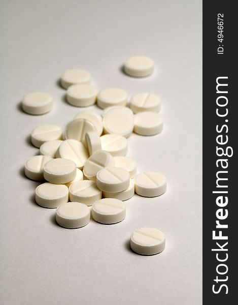 Several pills, distance blur, grey and white color