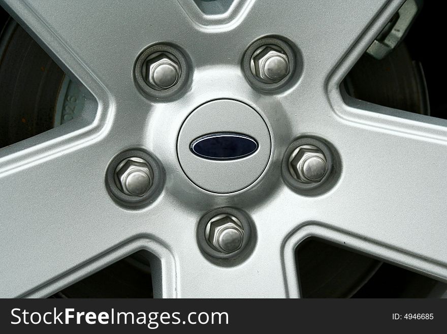 A Car tire wheel and lug nuts IMAGE