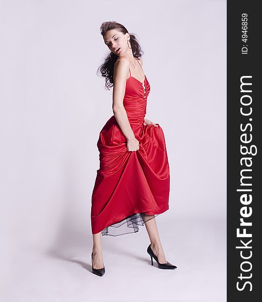 Young woman wearing red dress dancing by herself. Young woman wearing red dress dancing by herself