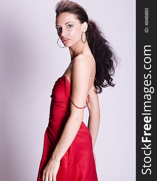 Profile shot of a young woman in a red dress with the strap off her shoulder. Profile shot of a young woman in a red dress with the strap off her shoulder