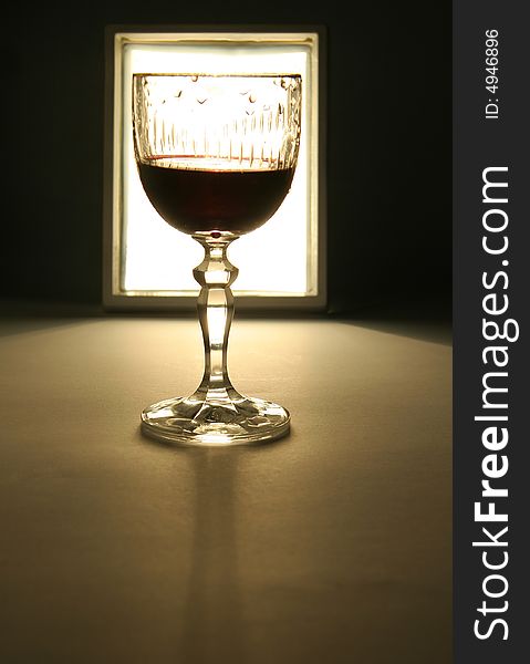 Glass of wine silhouette, white light in background