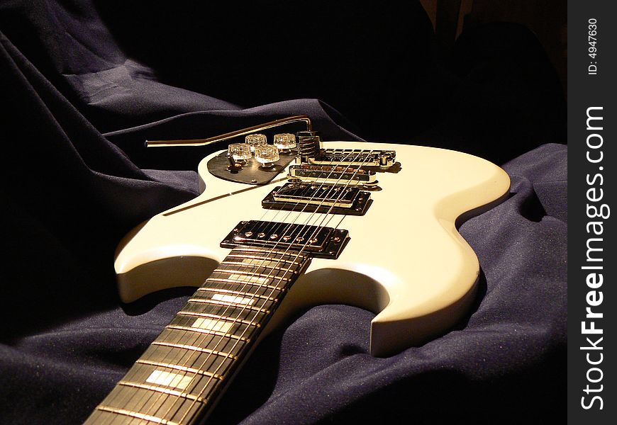 White electric guitar on dark background