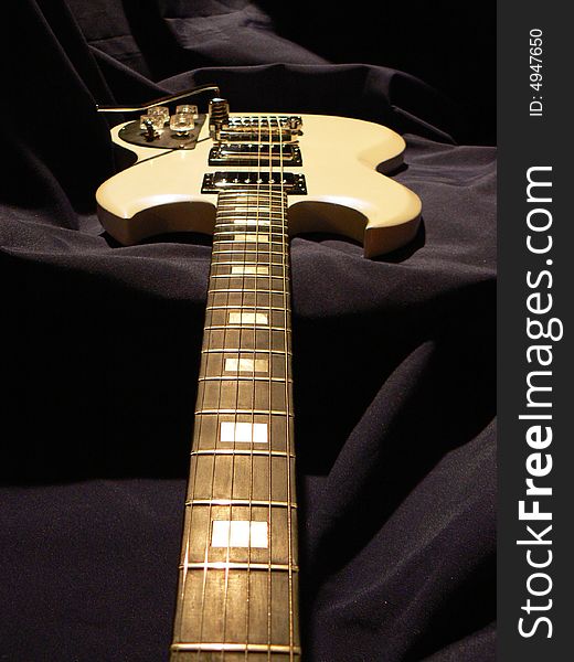 White electric guitar on dark background