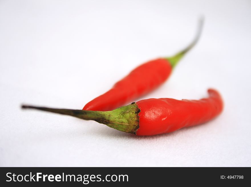 Close-up of two little red peppers on a light background