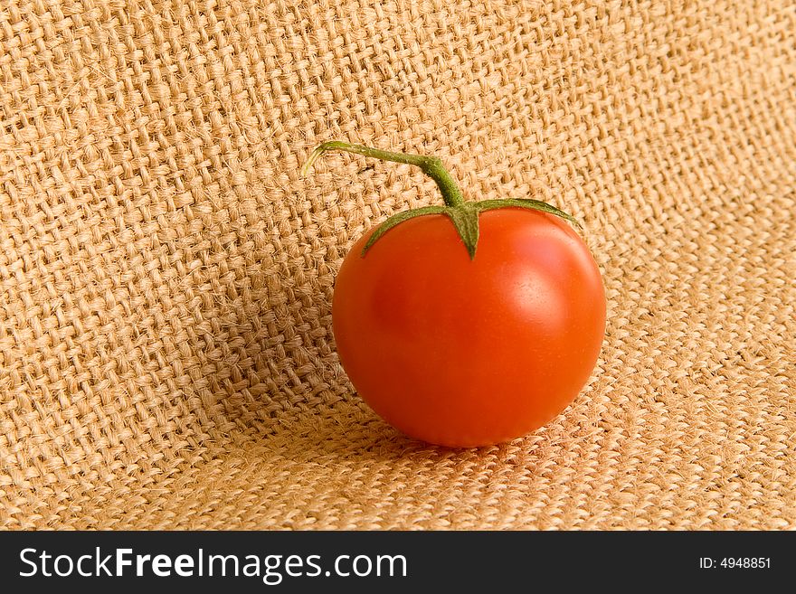 One small tomato at the canvas background