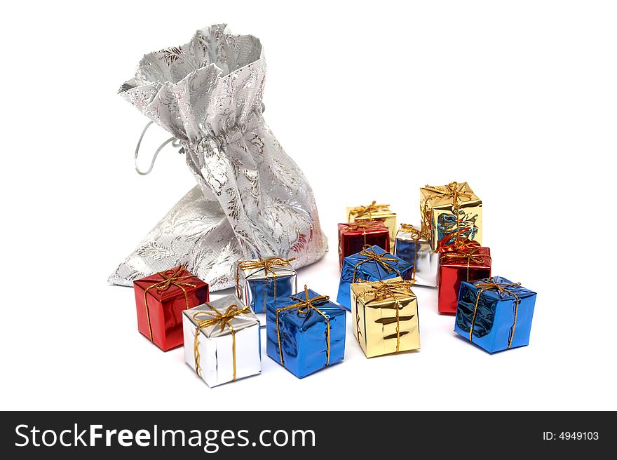 The gifts which are dropping out of a silver bag on a white background