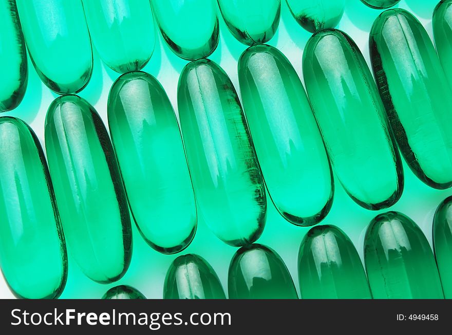 Green capsules on white background in rows, horizontal image. Green capsules on white background in rows, horizontal image