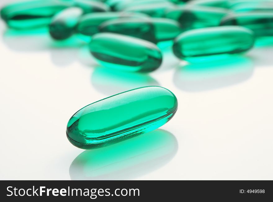 Green capsules on white background, horizontal image
