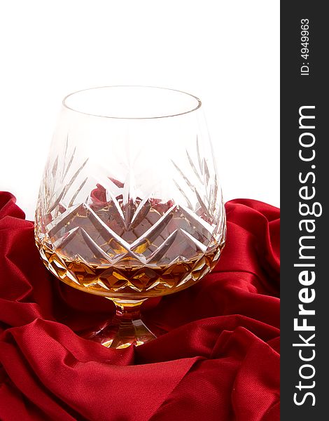 Glass of cognac on a red silk