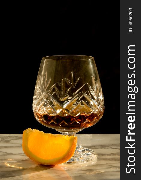 Soft focus glass of cognac with orange. Soft focus glass of cognac with orange