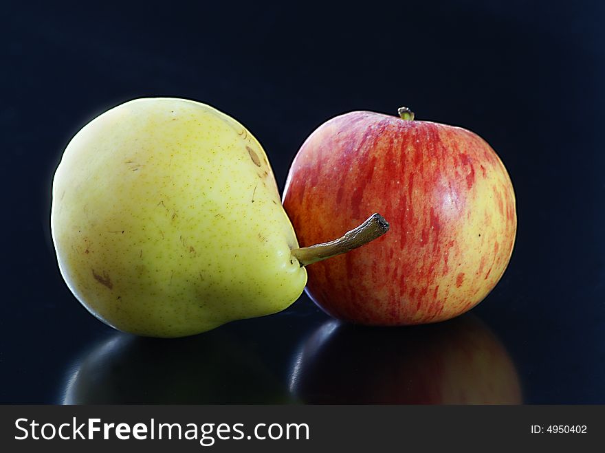 Close up of green pear and red apple on a black background. Close up of green pear and red apple on a black background