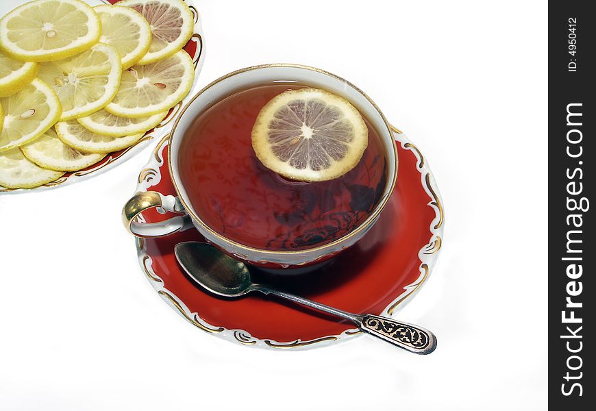 Ancient teacup with black tea and lemon