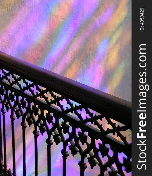 Colour light reflexes filtering from a stainglass window in a church creating a rainbow effect. Colour light reflexes filtering from a stainglass window in a church creating a rainbow effect.