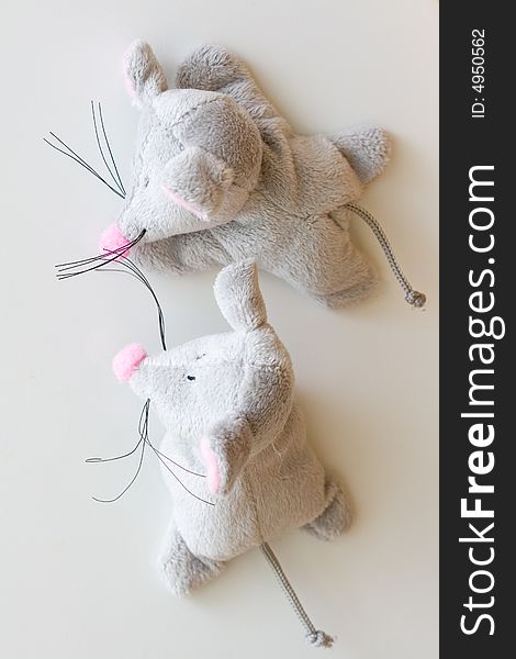 Two gray toy mouses on gray background