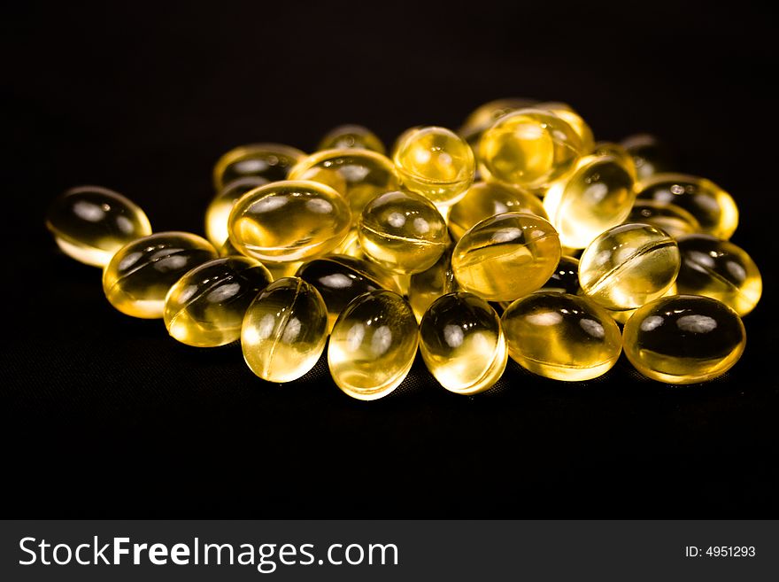 Cod liver oil tablets on a black background