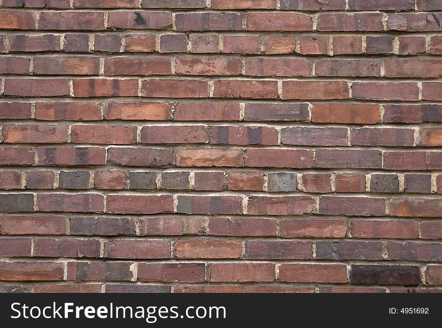 Dark brown red brick wall that could be used for a background.