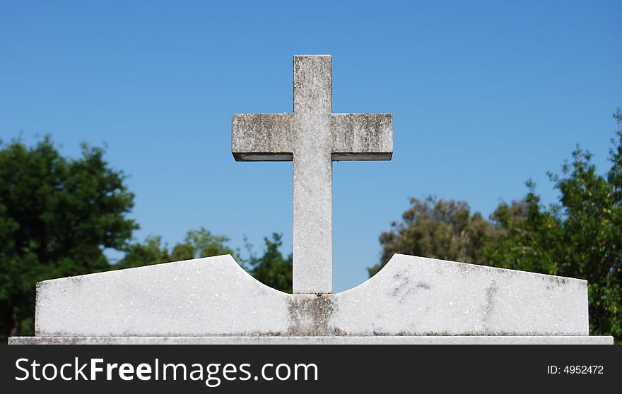 Cross on top of a tombstone in an old cemetery. Cross on top of a tombstone in an old cemetery