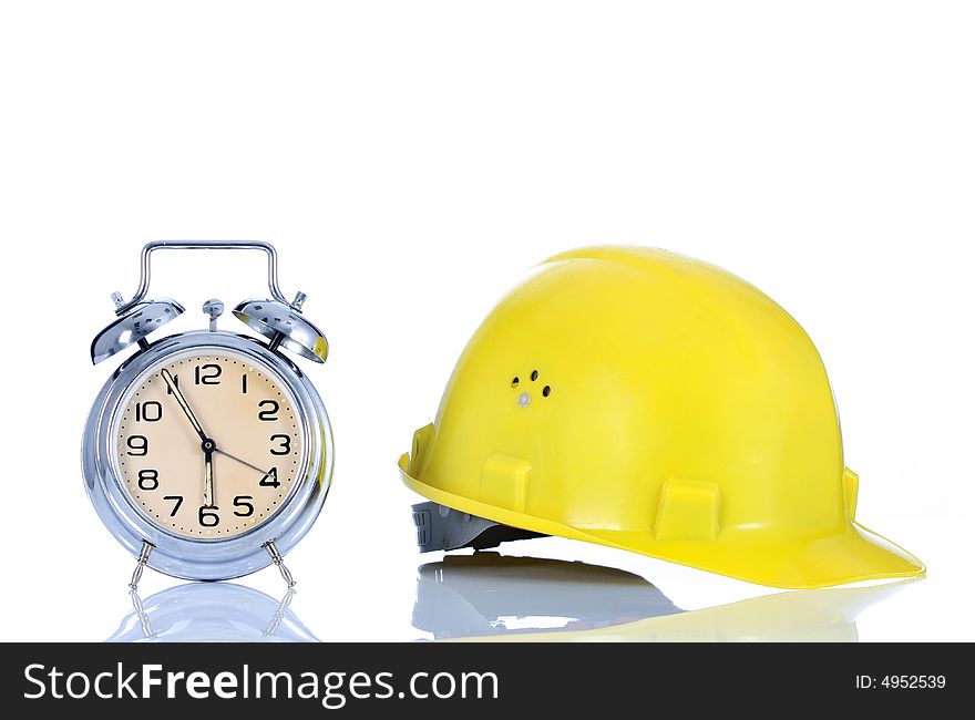 Alarm clock and helmet on white background