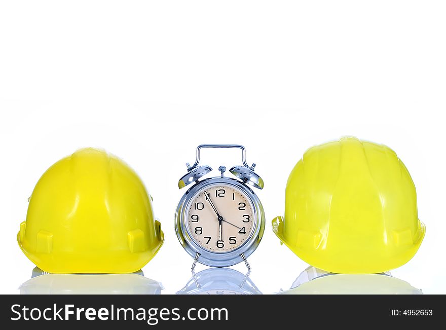 Alarm clock and helmet on white background