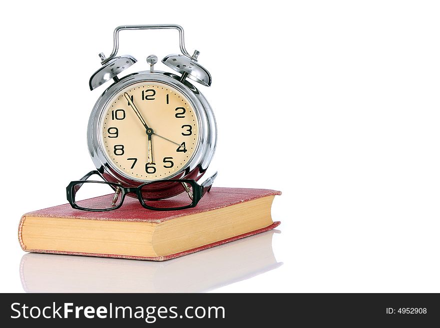 Book with alarm clock and eyeglasses on white background