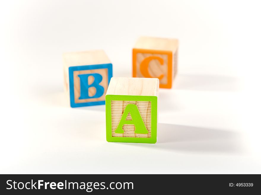 ABC blocks laying on a white surface. ABC blocks laying on a white surface