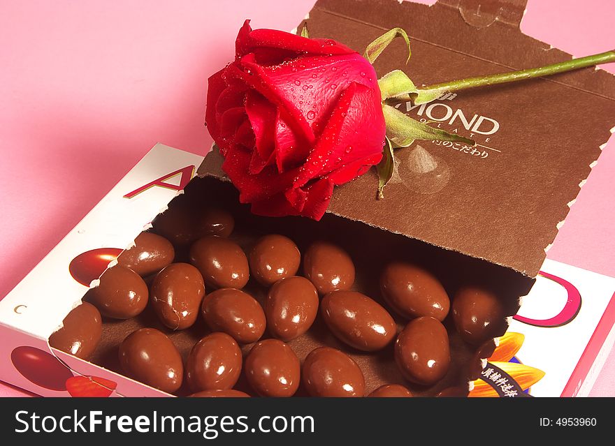 some almond chocolates in box and rose. some almond chocolates in box and rose