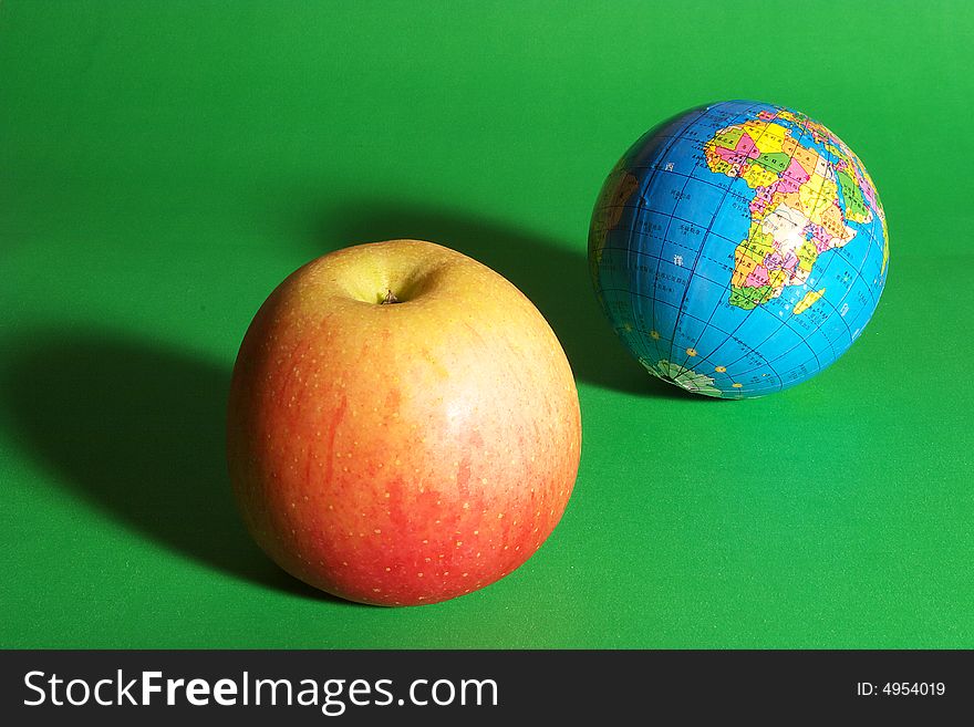 a globe and an apple. a globe and an apple