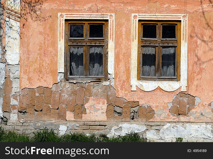 Close-up of house wall with two old windows. Close-up of house wall with two old windows