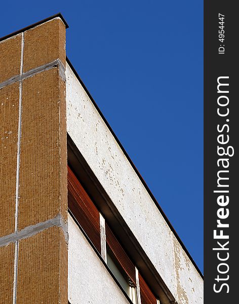 Close-up of urban building wall and windows isolated over blue sky