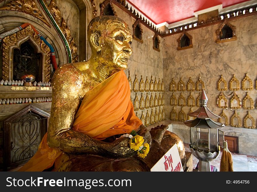 A seated buddha statue covered in gold leaf in a buddhist temple in Thailand. A seated buddha statue covered in gold leaf in a buddhist temple in Thailand.