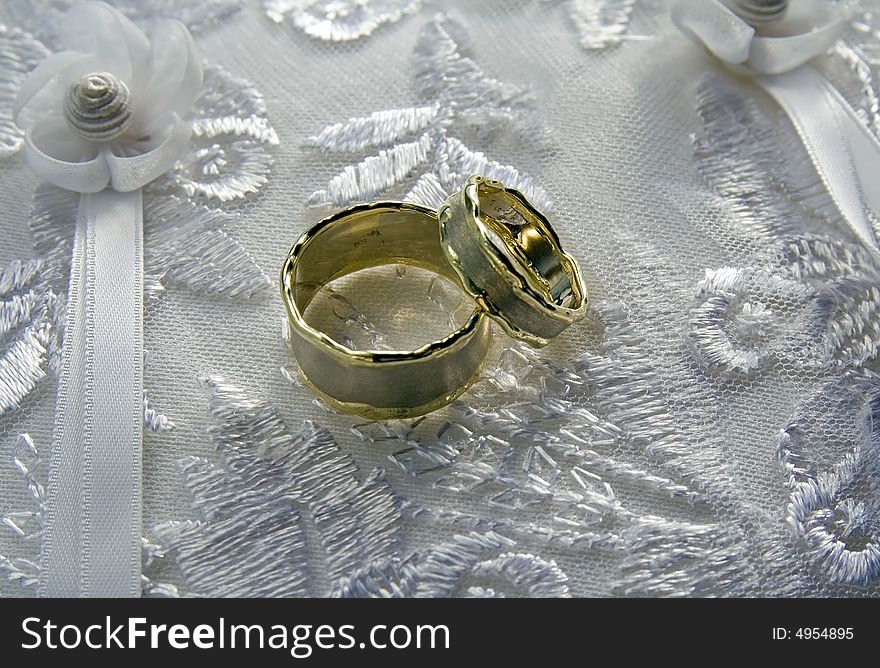 Unique wedding rings on a silk pillow.