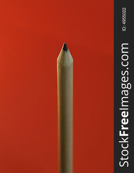 A pencil with a simple red color background