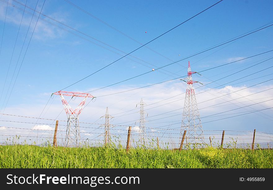 Electricity pylon and power cables over farmland in Italy