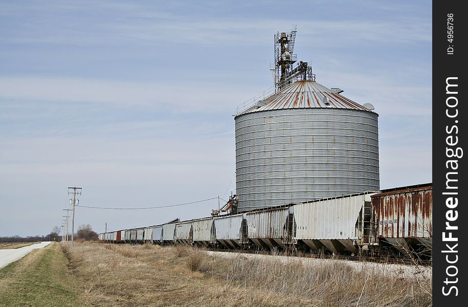 A series of grain cars being loaded with corn at a grain elevator in the midwest. A series of grain cars being loaded with corn at a grain elevator in the midwest