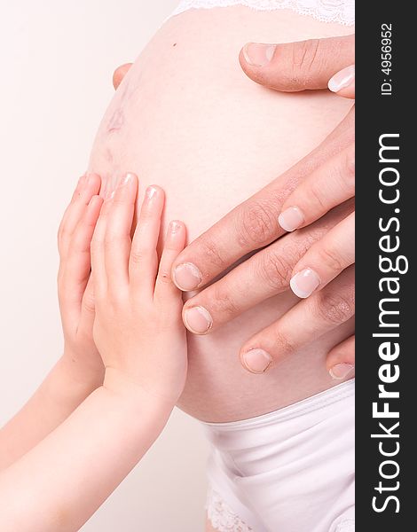 Hands of father, mother and child on pregnant belly. Hands of father, mother and child on pregnant belly