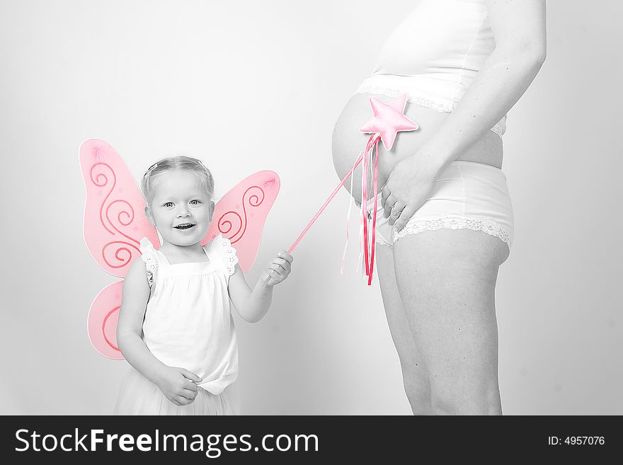 A little fairy points her magic wand at her mothers pregnant belly so that a brother or sister will come out!. A little fairy points her magic wand at her mothers pregnant belly so that a brother or sister will come out!