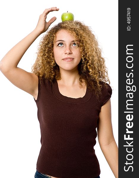 A young woman balancing a green apple on her head. A young woman balancing a green apple on her head