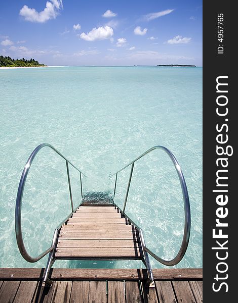 Jetty leading into tropical sea, Maldives