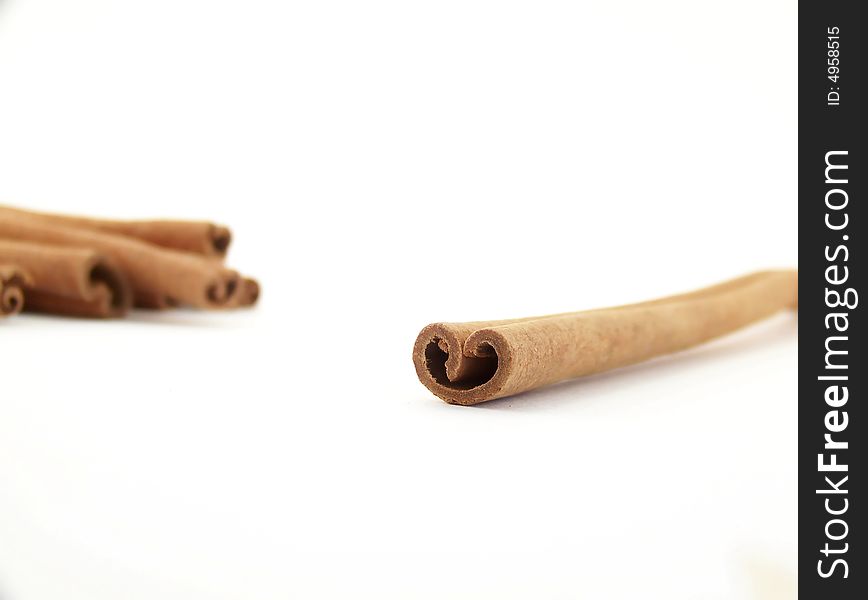 Horizontal image of a single cinnamon stick with others visible in the background. Horizontal image of a single cinnamon stick with others visible in the background.