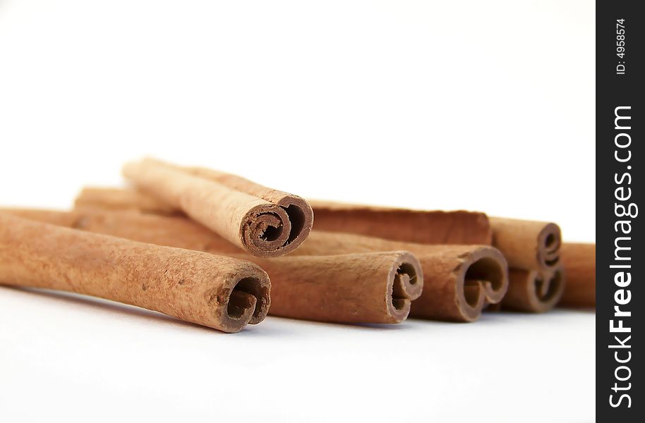 Horizontal image of cinnamon sticks, angled in the frame.