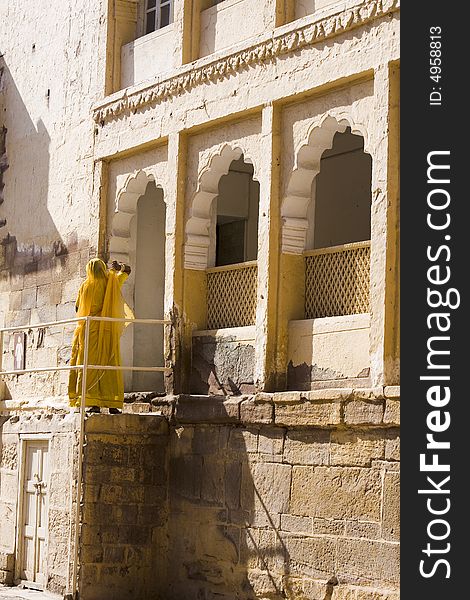 Hindu woman in yellow sari in front of a Rajastan temple. Hindu woman in yellow sari in front of a Rajastan temple