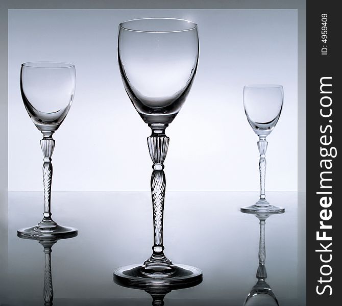 Three glasses on a mirroring plate