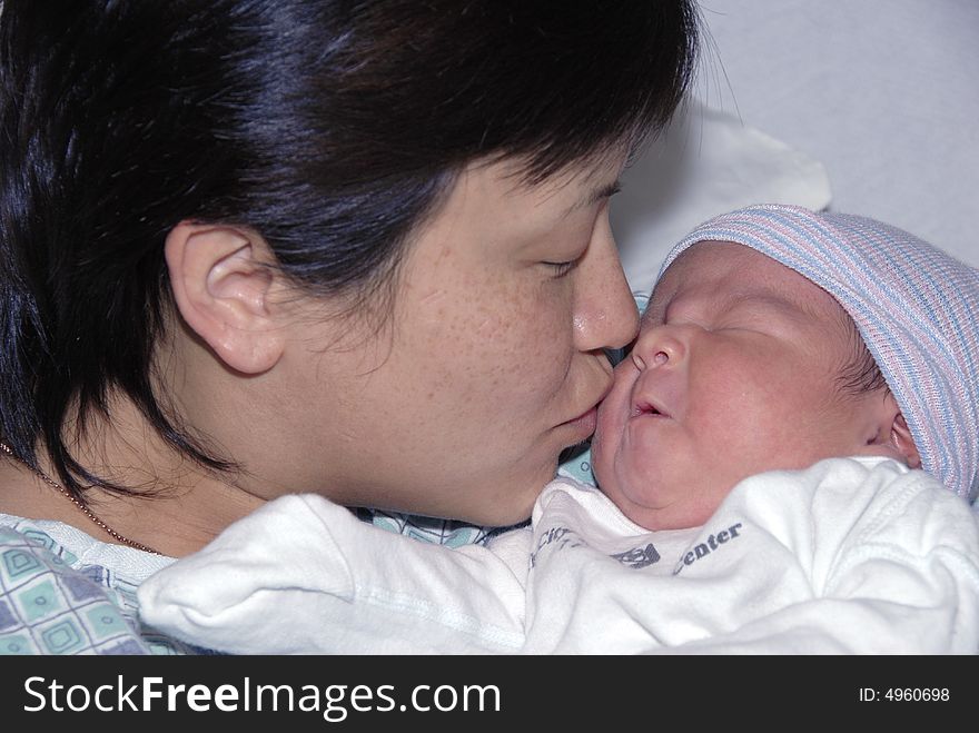 Mother kissing her new child. Mother kissing her new child