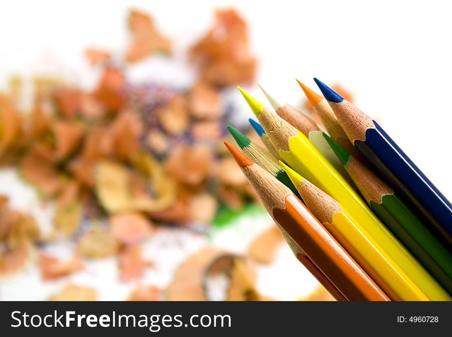 Coloured pencils over sawdust background