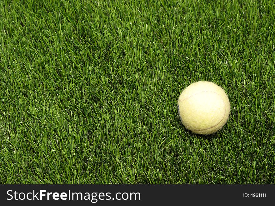 Yellow tennis ball on the man-made lawn. Yellow tennis ball on the man-made lawn