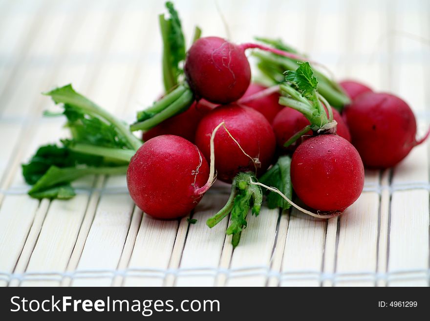Some red radishes on a wodden plate