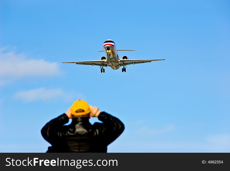 Aeroplane landing while an spectator looks on. Aeroplane landing while an spectator looks on